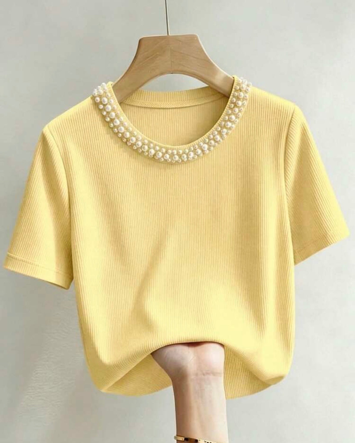 Blusa amarilla con perlas en el cuello